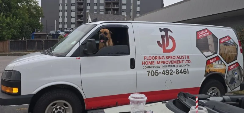 JD Flooring branded work van in North Bay with the shop dog, the Boss, riding up front